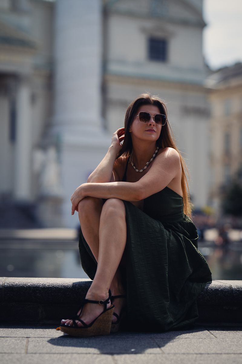 romantic portrait of a lady in green sitting in front of St. Charles Cathedral in Vienna