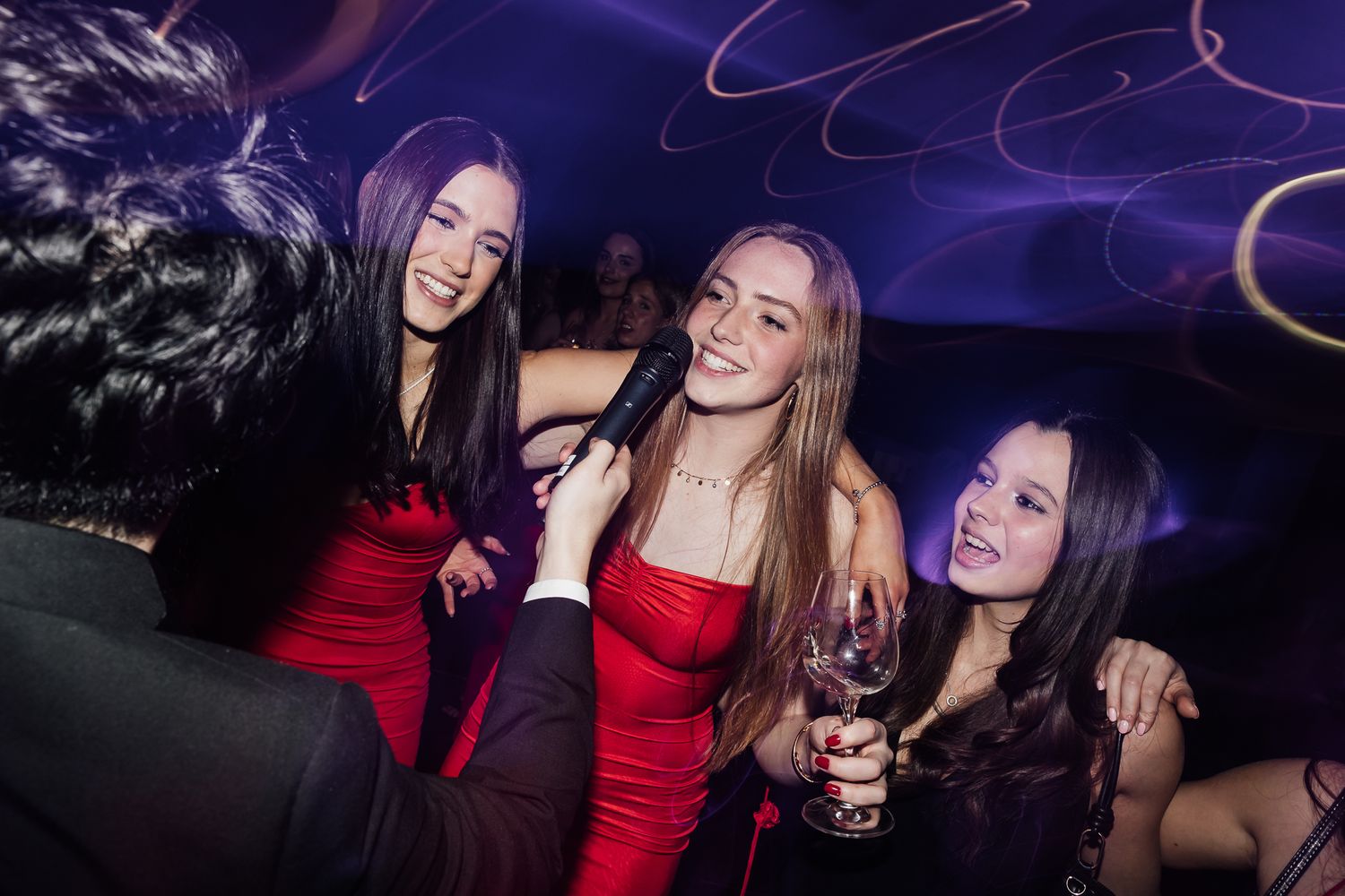 Friends enjoying a night out at a club with purple lighting and festive atmosphere.