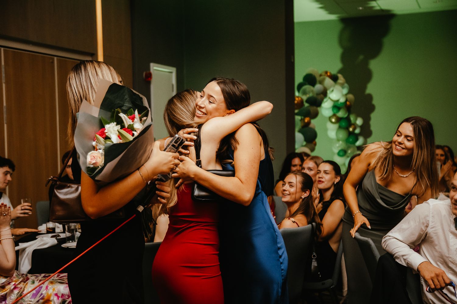 Celebratory moment at a party with guests embracing and laughing.