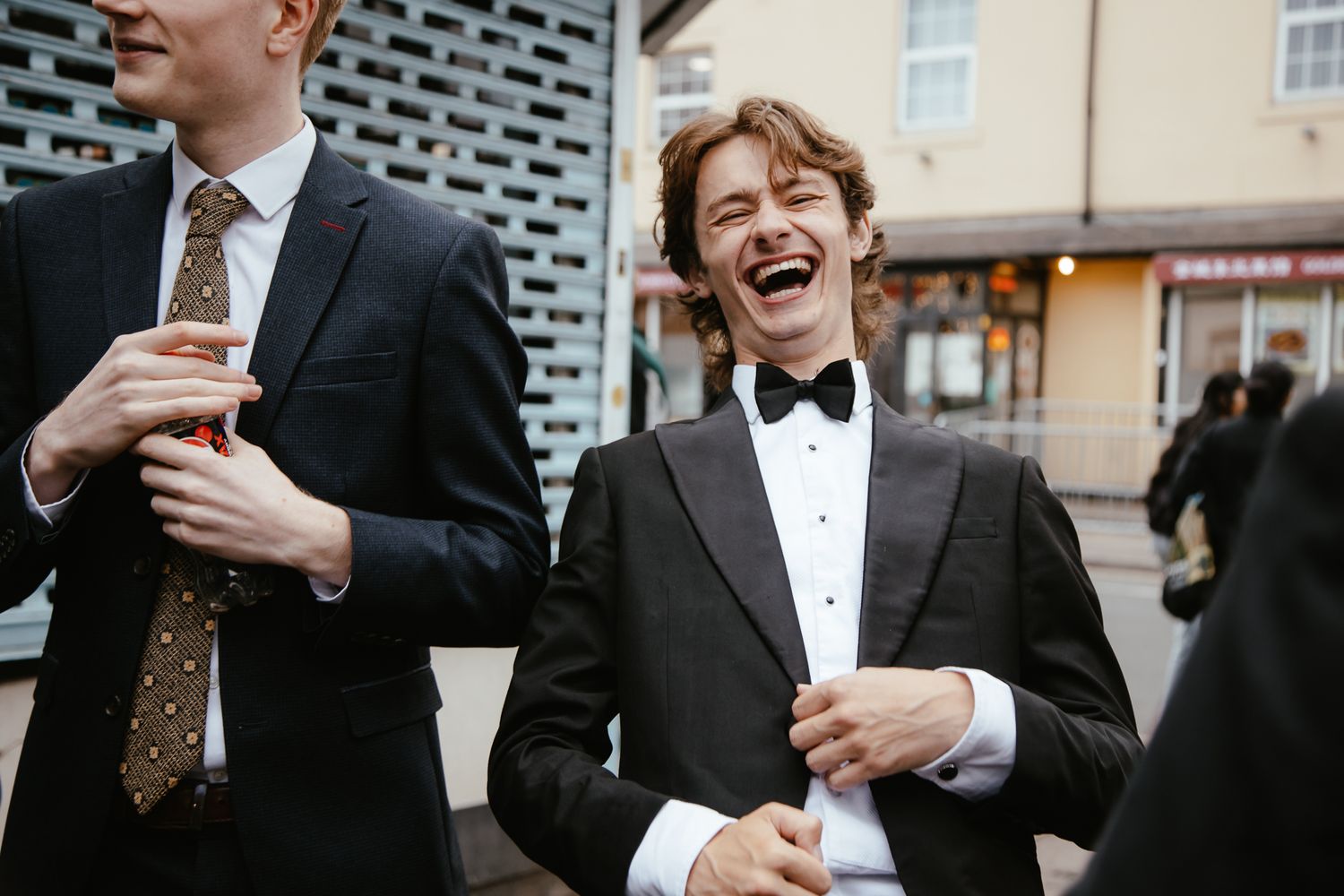 Wedding guests in formal attire gathered for group photos outdoors.