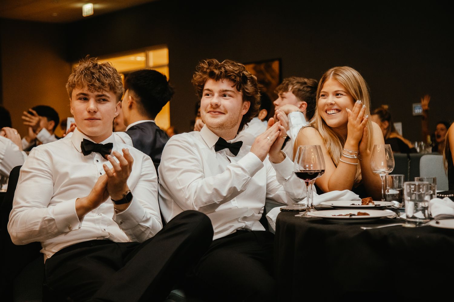 Formal dinner guests reacting with excitement during a reception event.