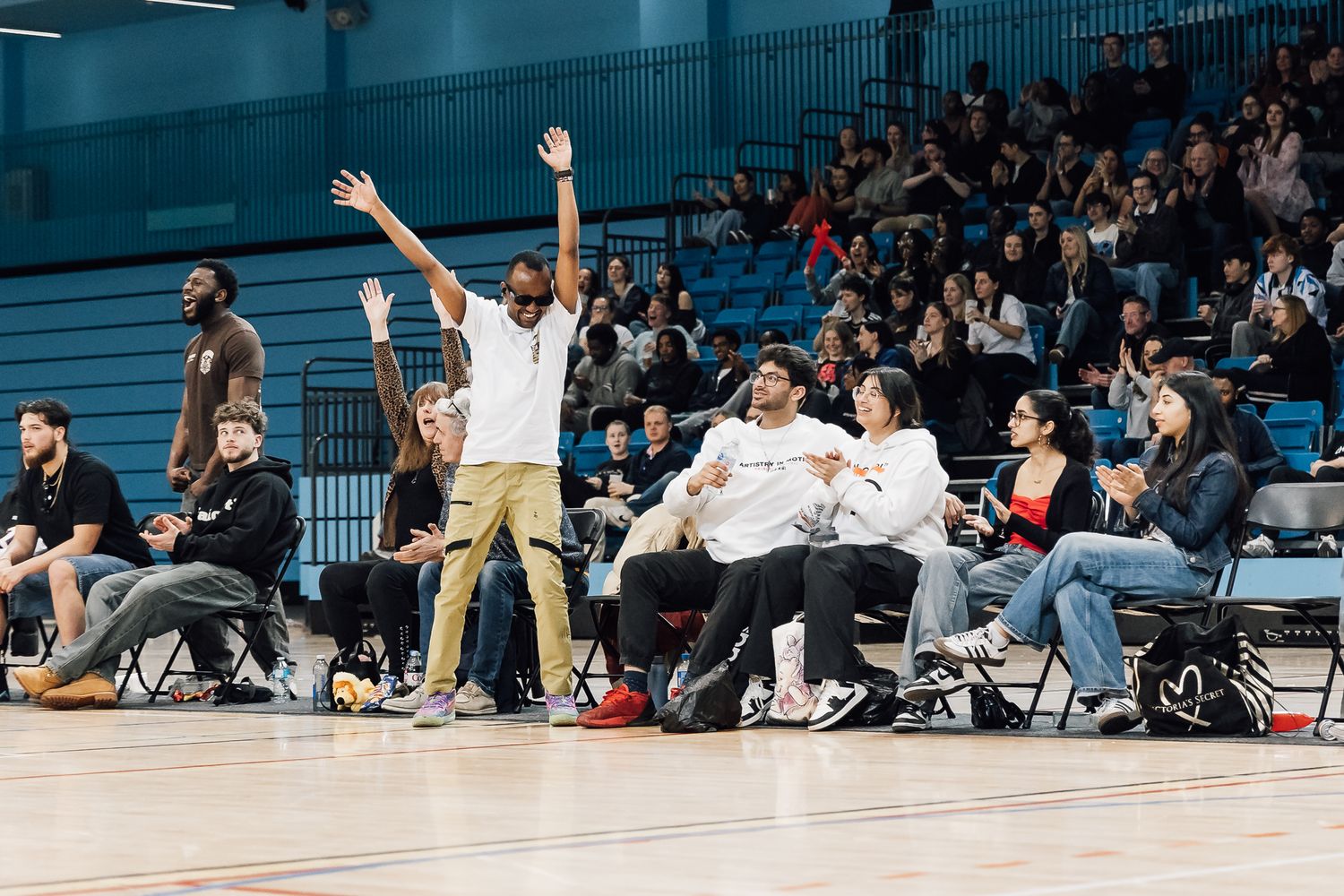 Panoramic view of basketball game with spectators watching from sidelines.