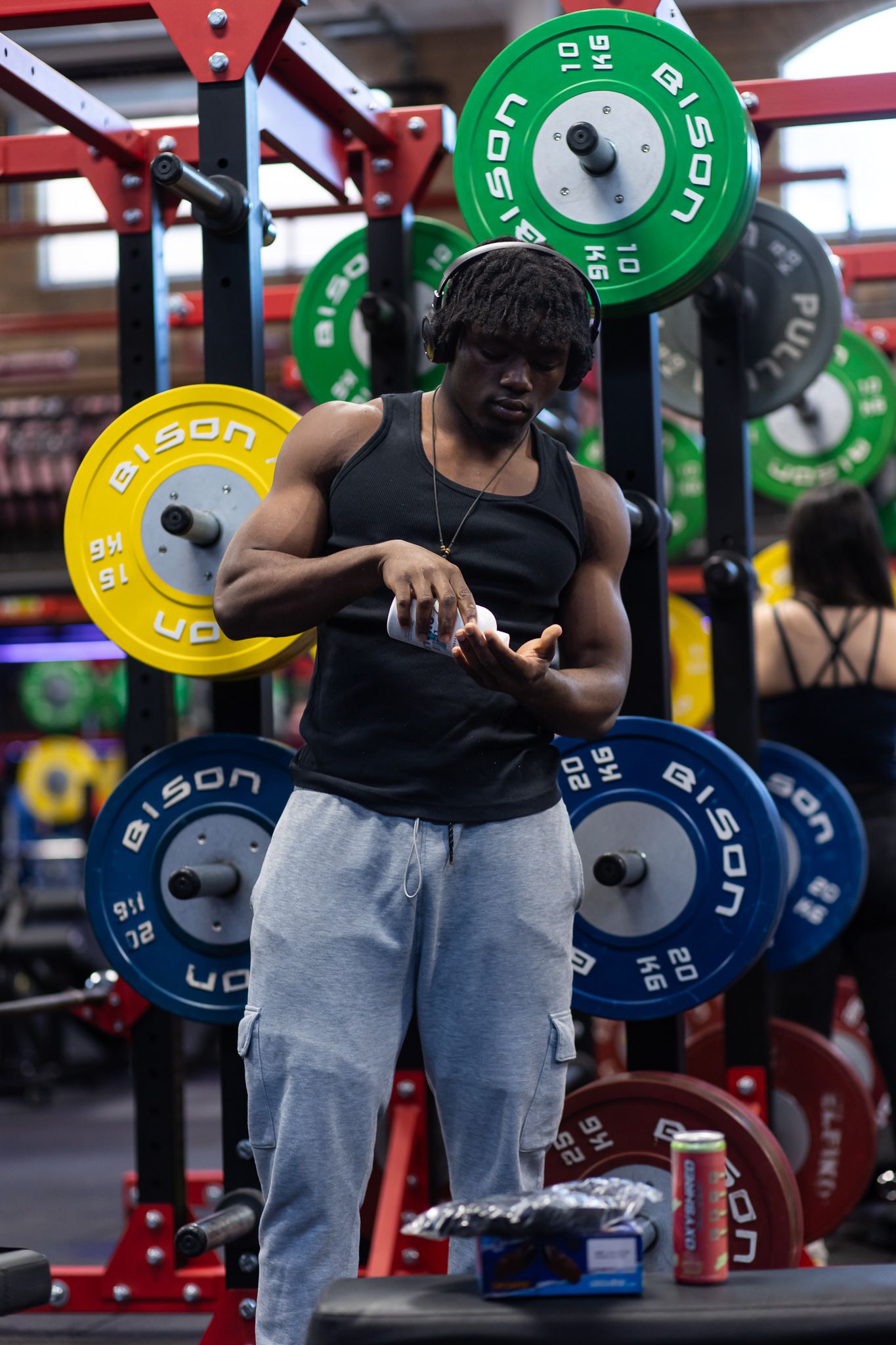 Weight room with colorful weight plates and training equipment arranged on racks.