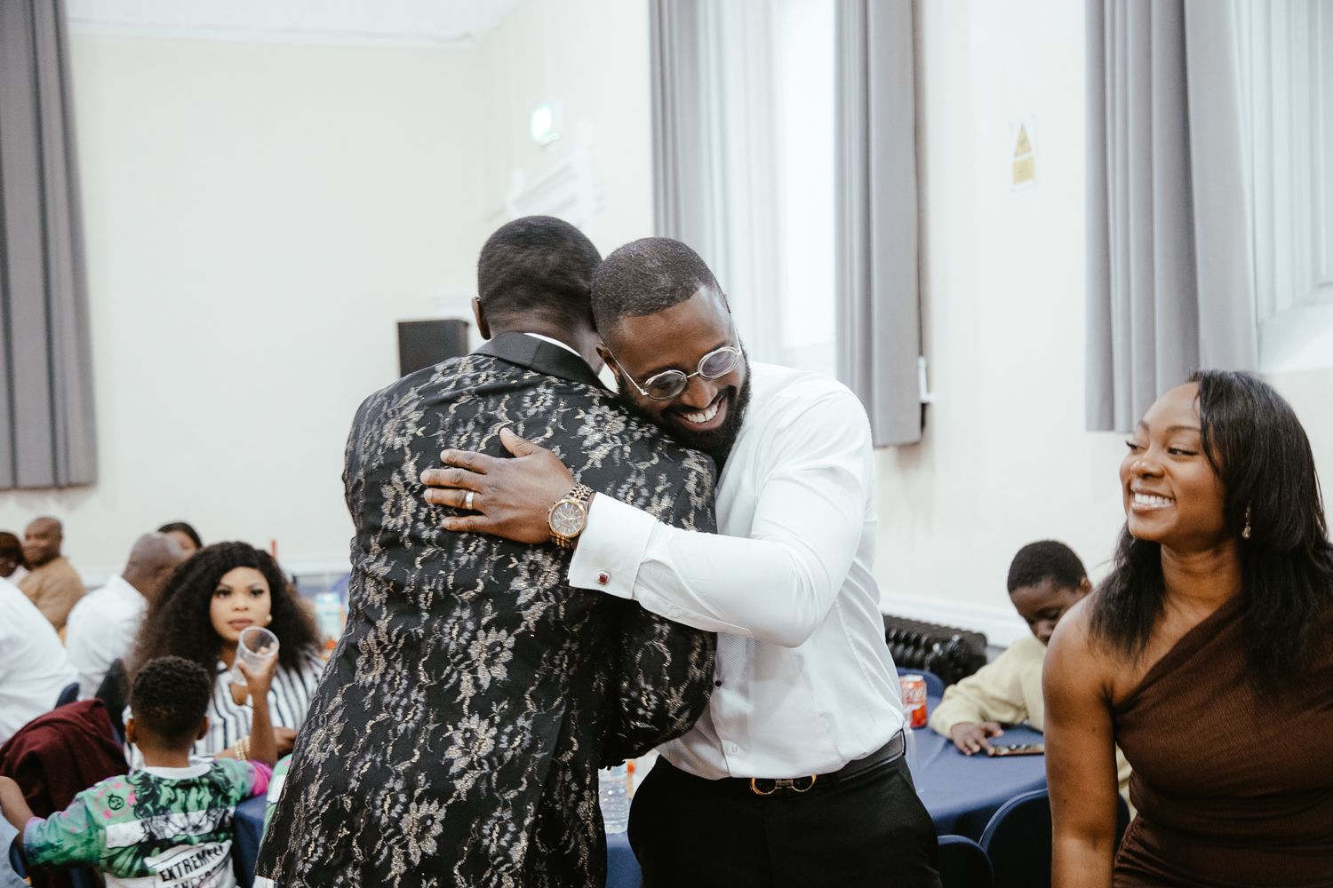 Wedding guests sharing an emotional embrace during a joyful celebration moment.
