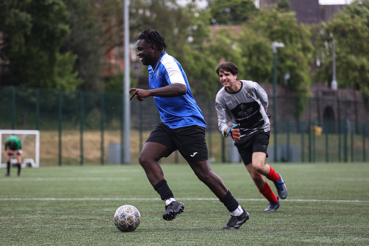 Players in different colored jerseys engaged in a competitive soccer match on an artificial turf field.