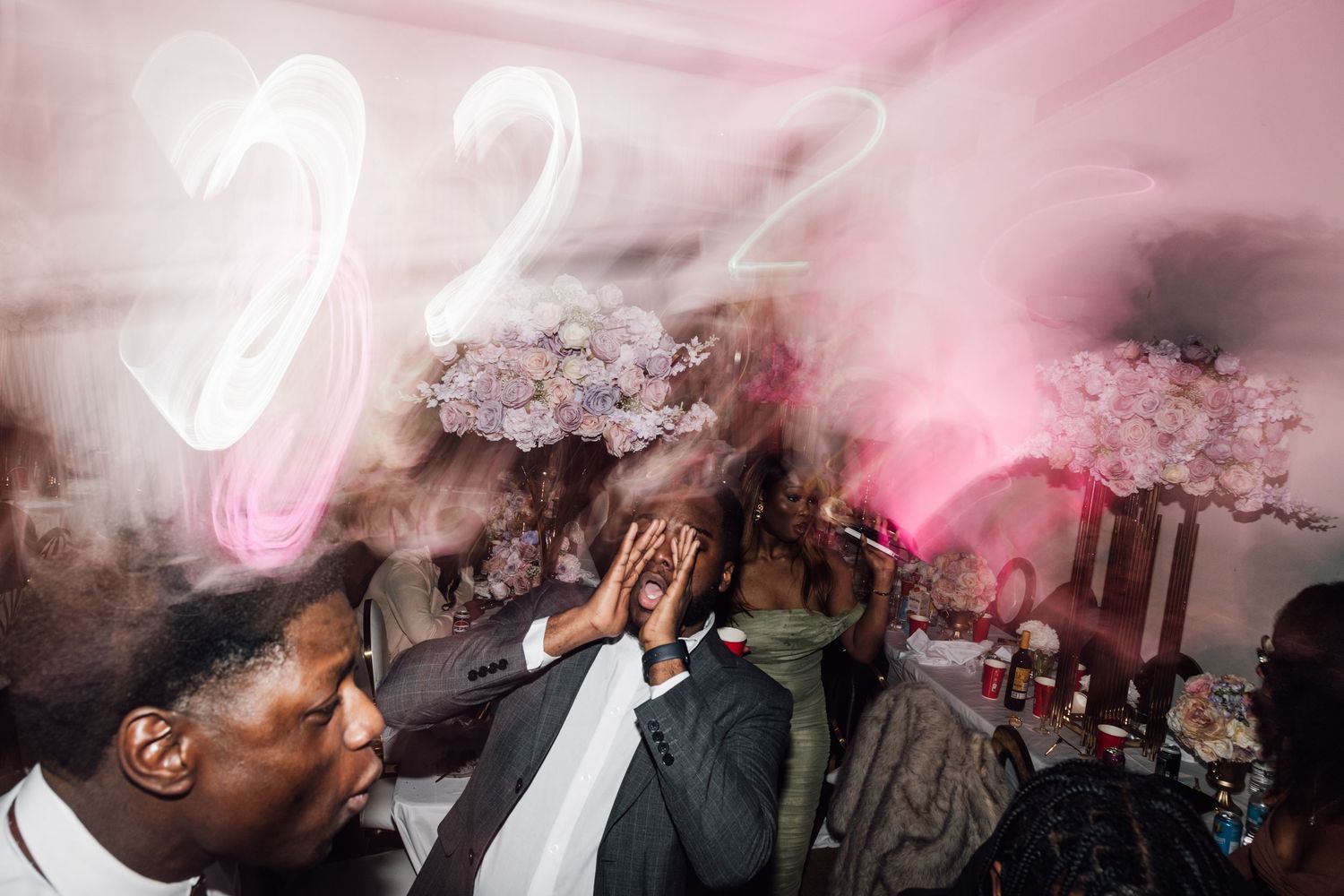 Pink smoke effects create dramatic atmosphere during wedding celebration.