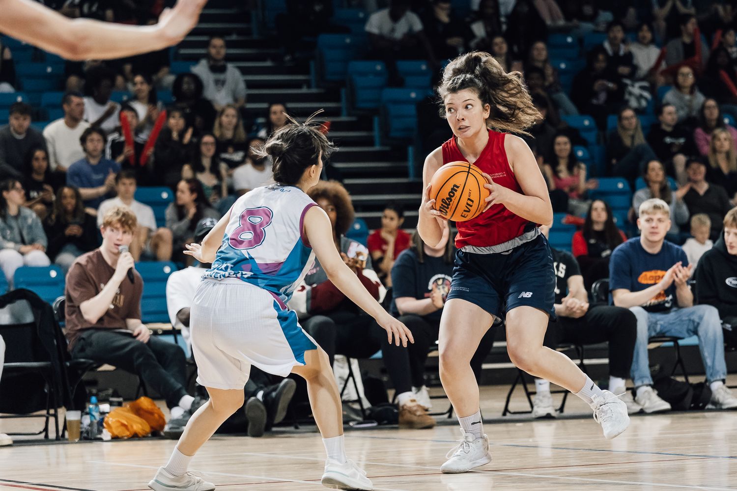 Basketball players diving and competing for loose ball during intense game action.