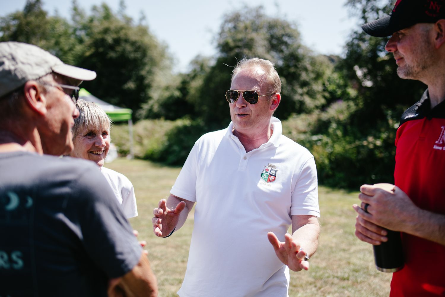 Outdoor event with group discussion at a summer gathering.