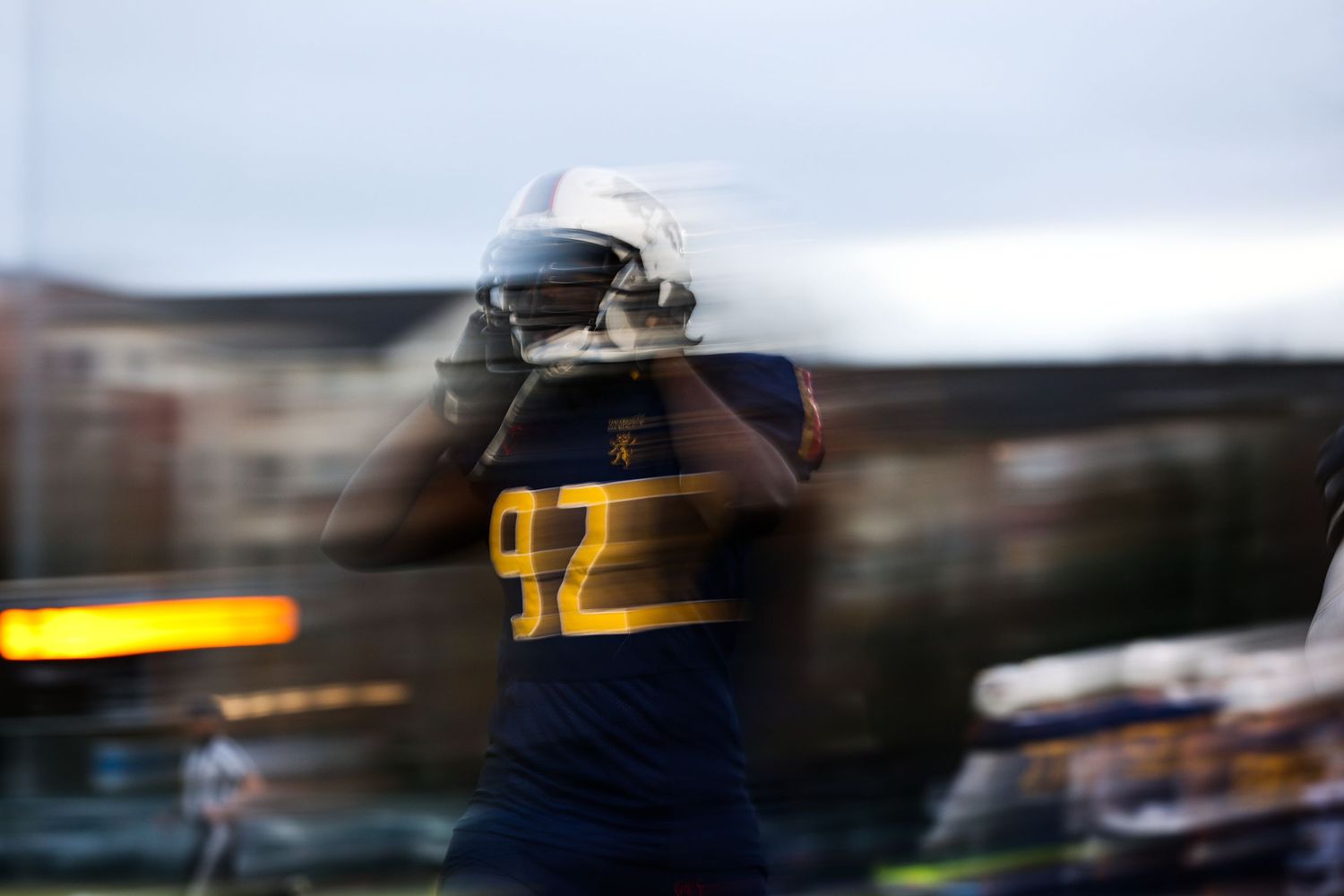 Blurred motion capture of athletes in motion on a sports field.