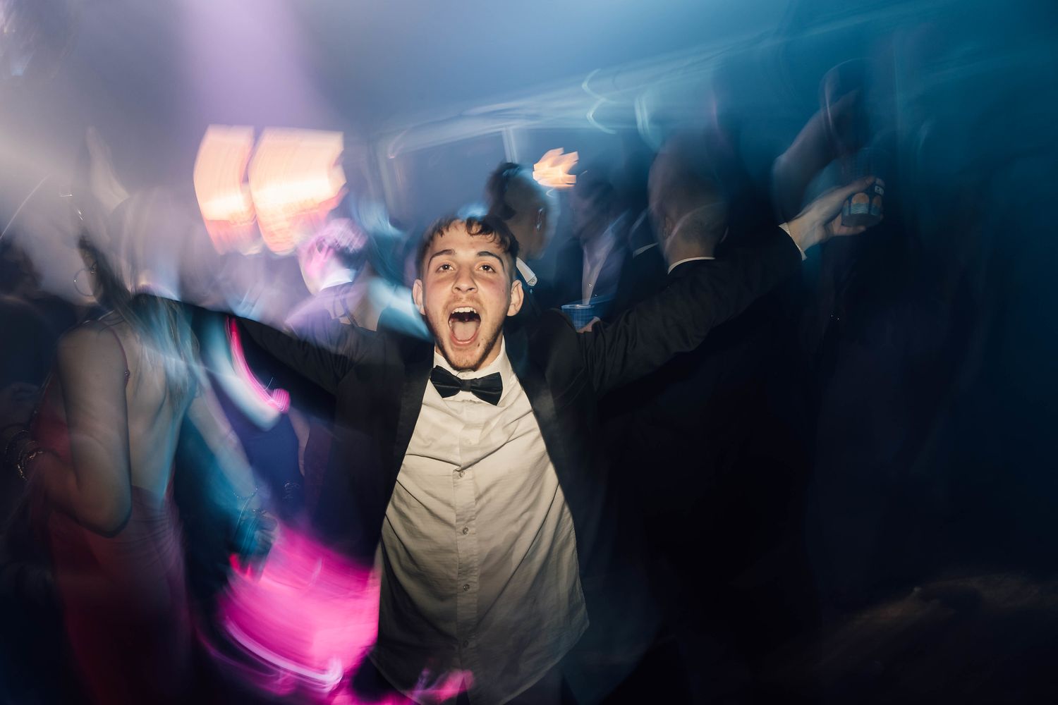 Dance party scene with colorful lighting and silhouettes of people dancing.