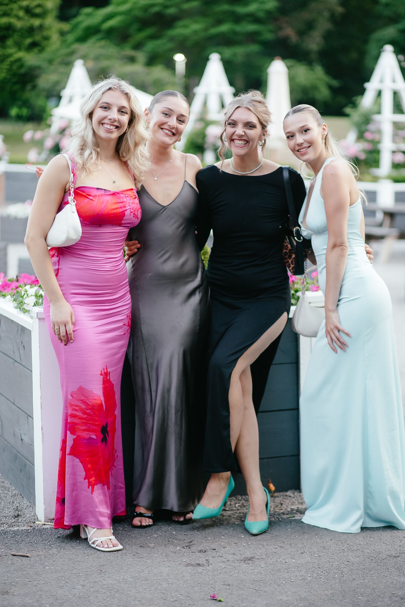 Wedding party members in colorful dresses pose together on outdoor steps for event photography