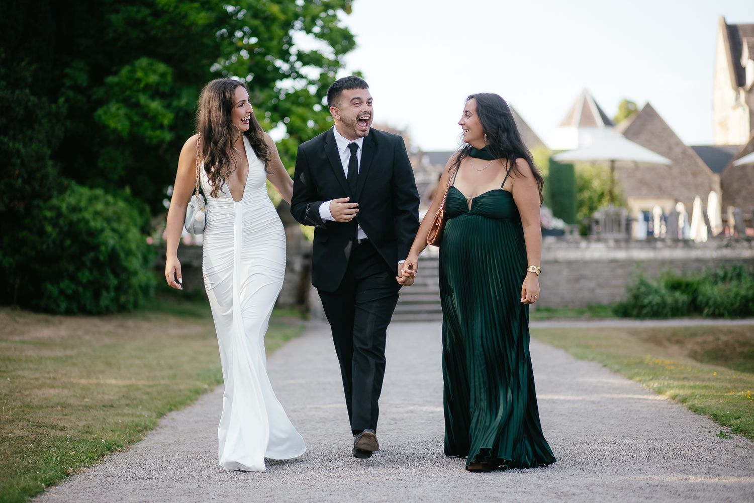 Wedding party walking together on an outdoor pathway at dusk.