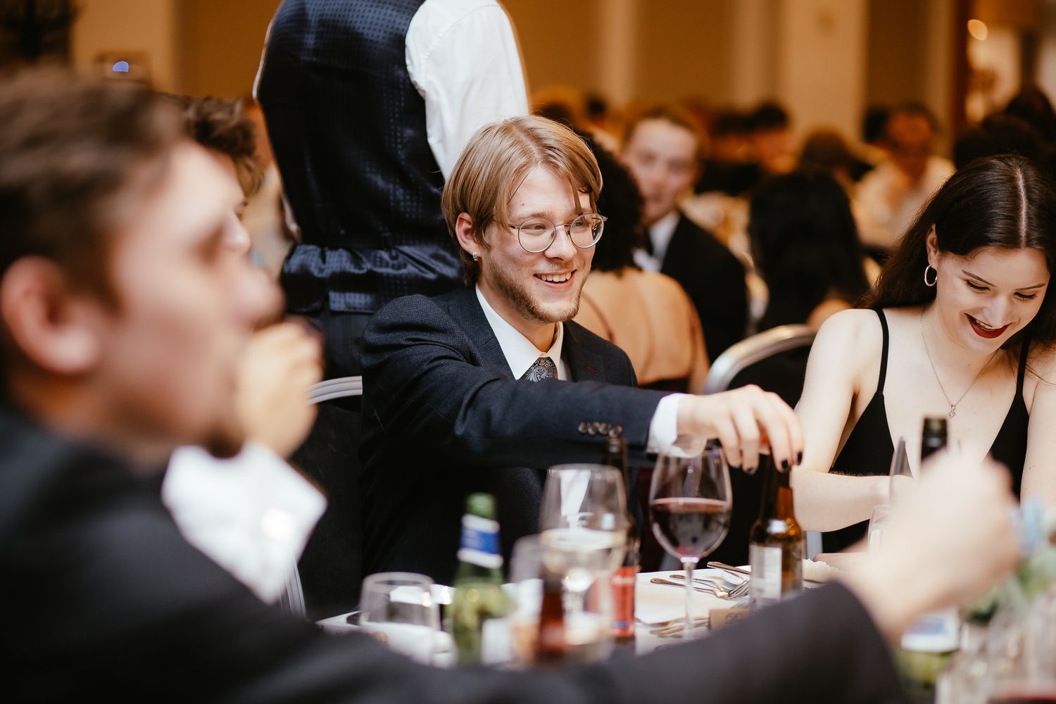 Wedding reception guests enjoying conversations at decorated banquet tables.