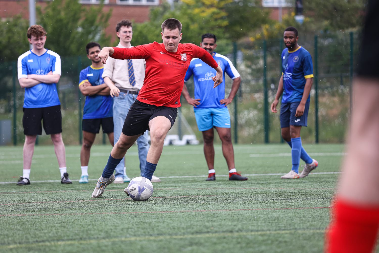 Players competing for the ball during a soccer match on a sunny day.