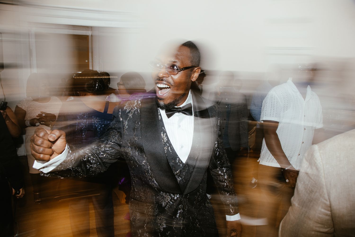 Artistic motion blur photograph of people dancing at formal celebration.