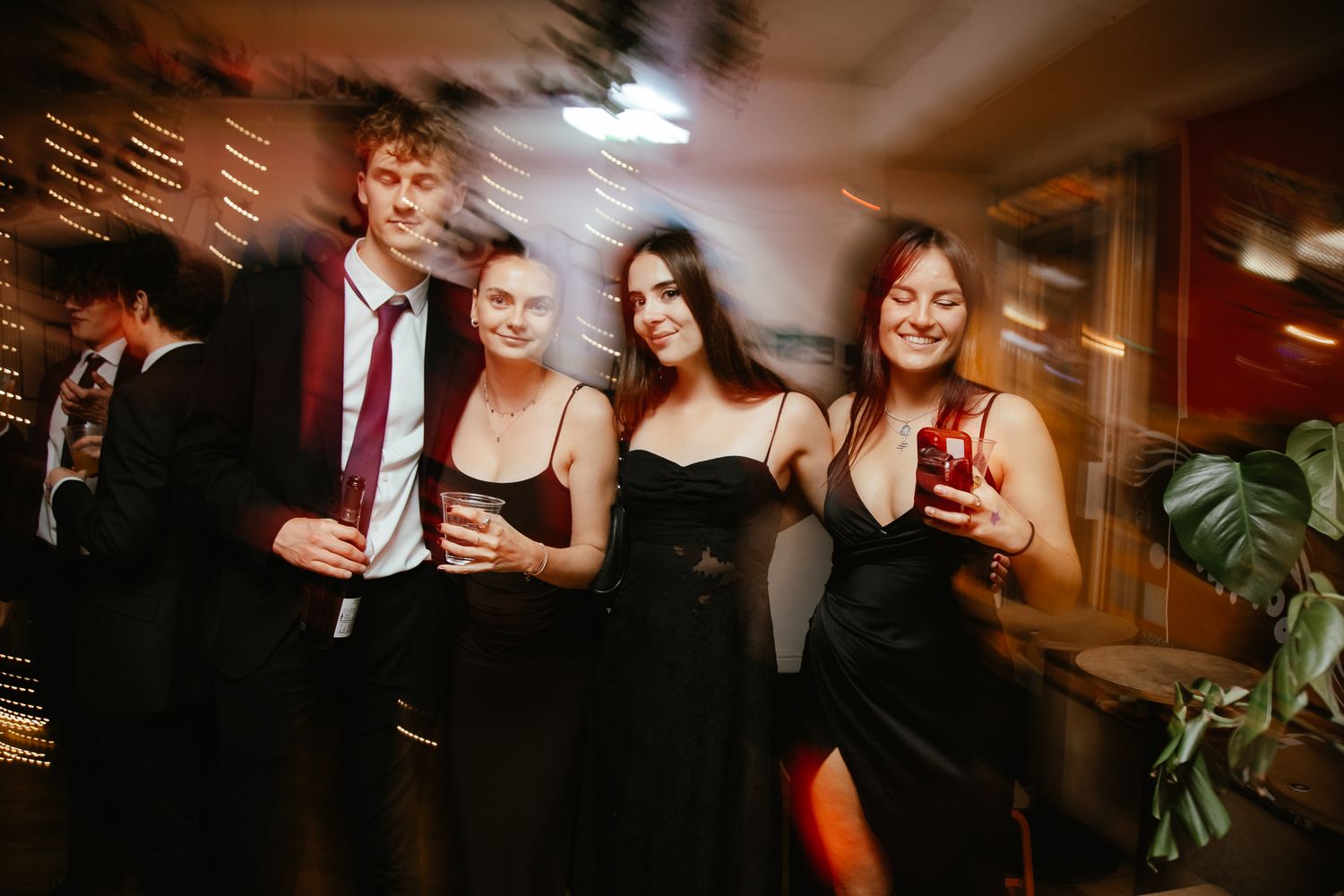 A small group enjoying drinks at an evening party in formal attire.