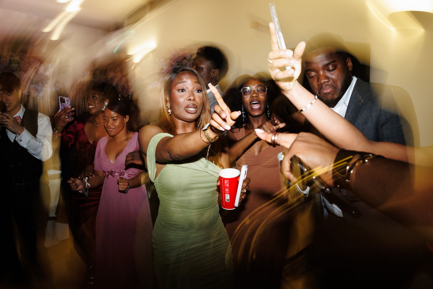 Party guests dancing and enjoying themselves at a lively indoor celebration.