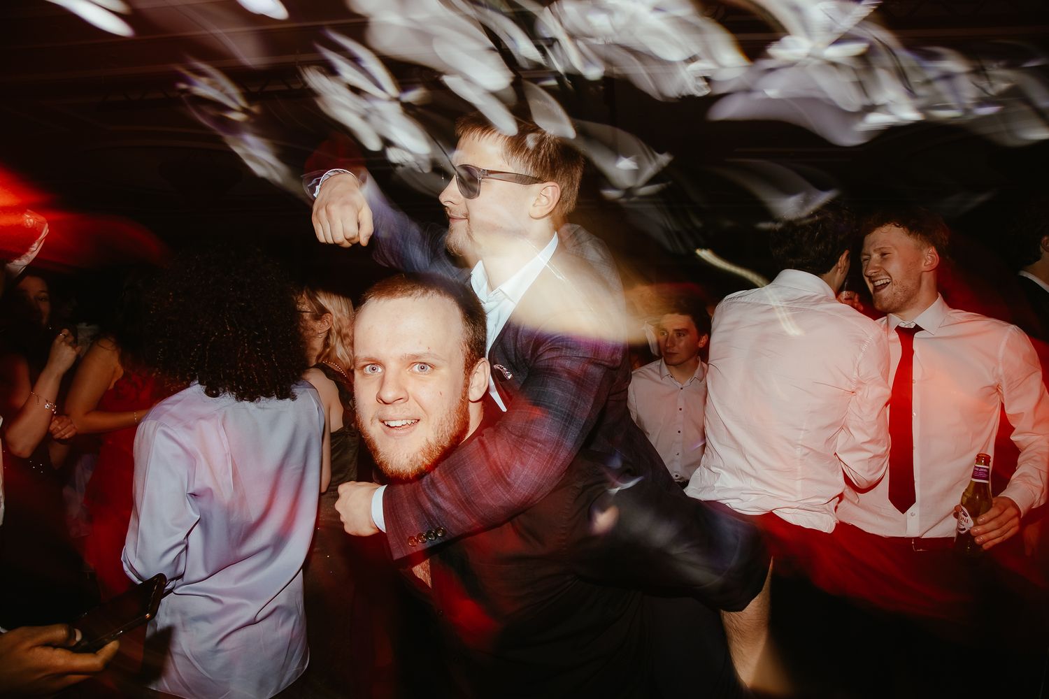 Lively dance floor scene with guests enjoying themselves under dynamic lighting.