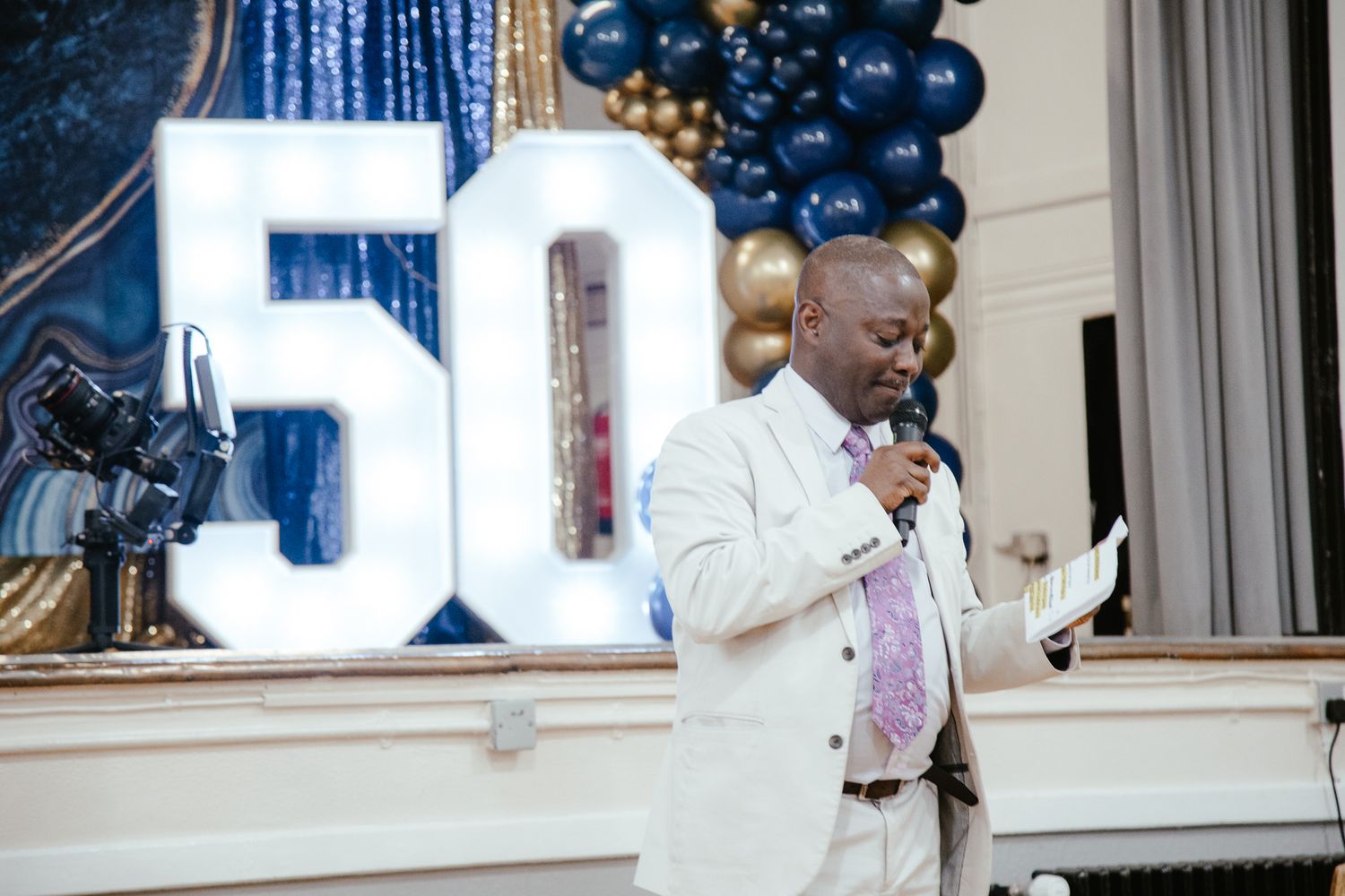 Elegant party setup with large illuminated 50 numbers and blue balloon decorations.