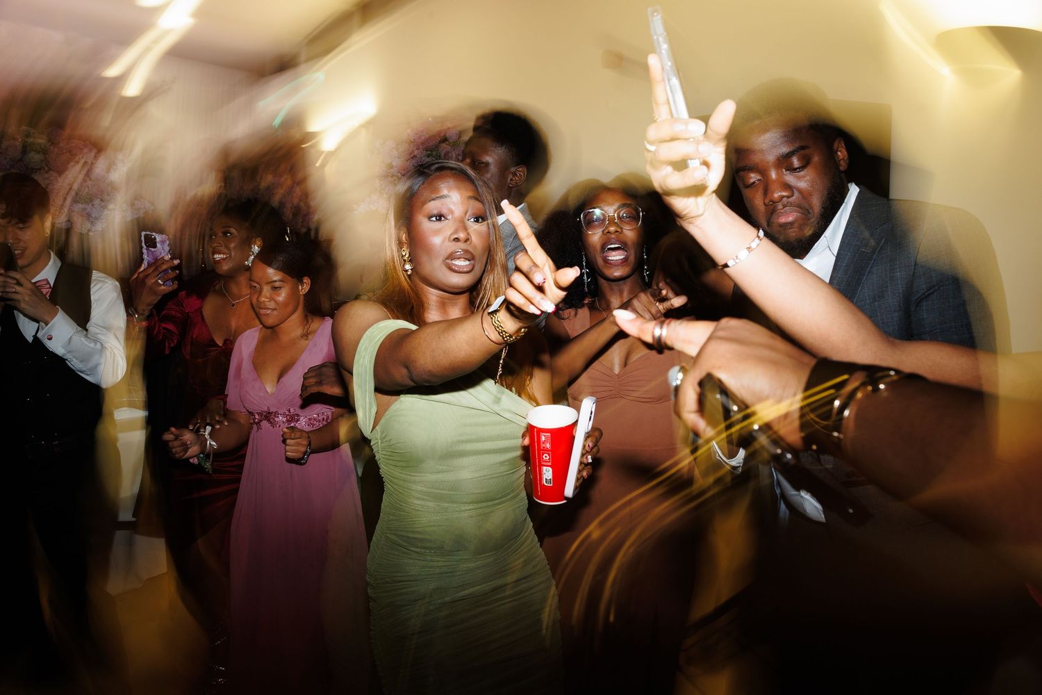 Candid shots of wedding guests dancing and having fun at evening reception.