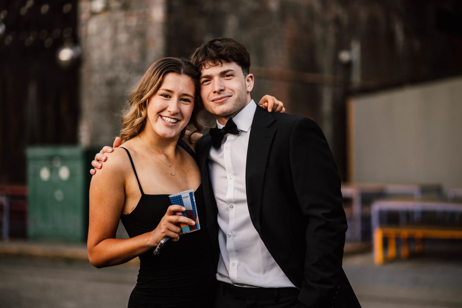 Candid evening celebration moments captured in a dark urban setting.