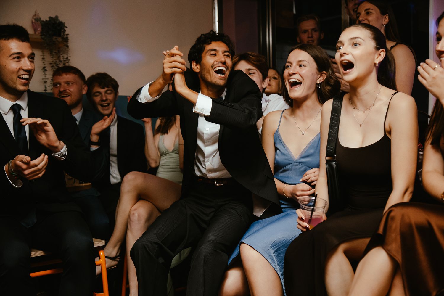 Energetic crowd dancing and laughing at a lively party.