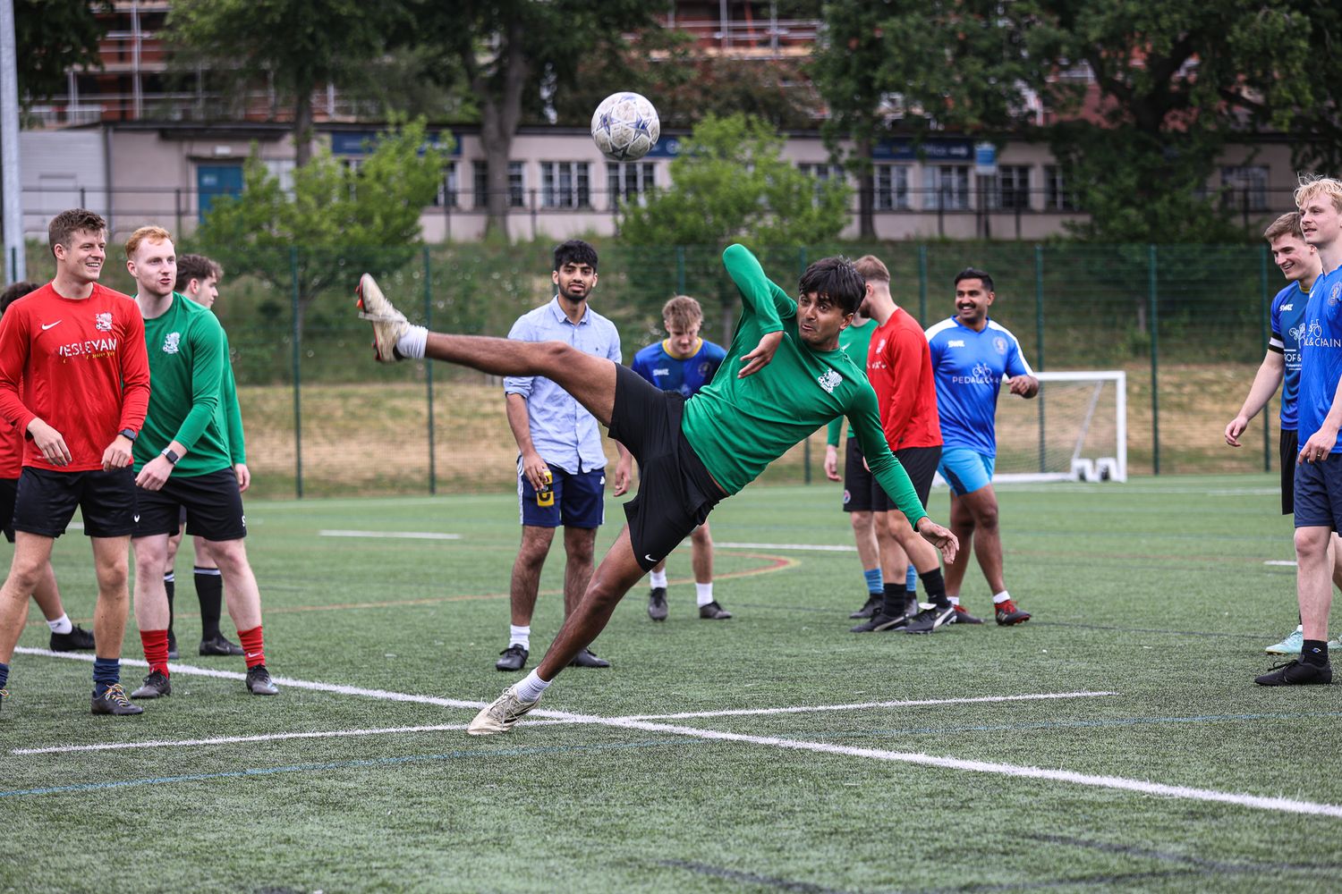 Soccer players practicing diving techniques and drills on an outdoor training field.