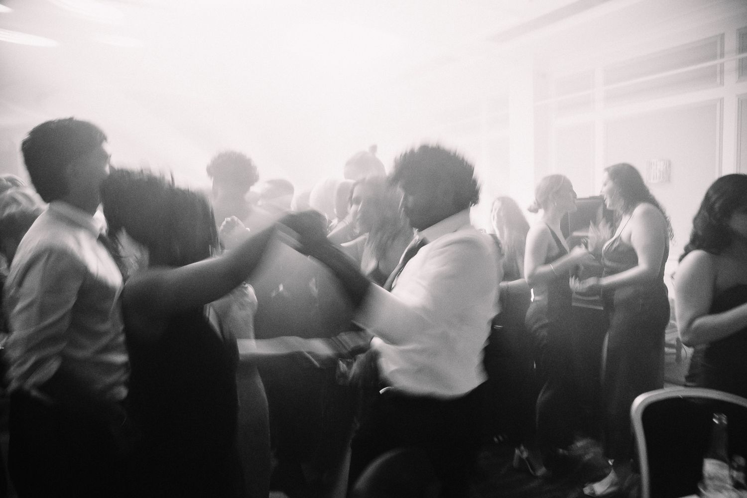 Silhouettes of people dancing and celebrating in a misty, dramatically lit space.