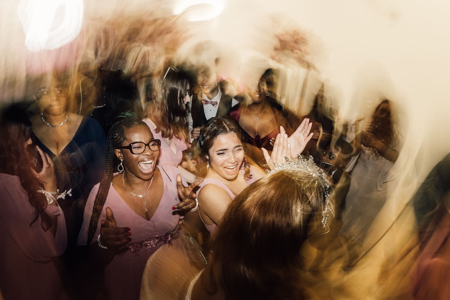 People enjoying a lively celebration in a dimly lit venue with a blurred motion effect.
