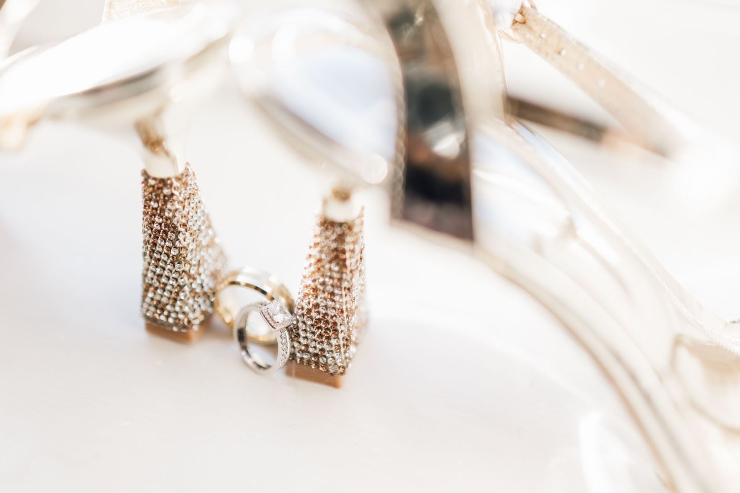 Elegant wedding ring and jewelry details captured in a bright white setting.