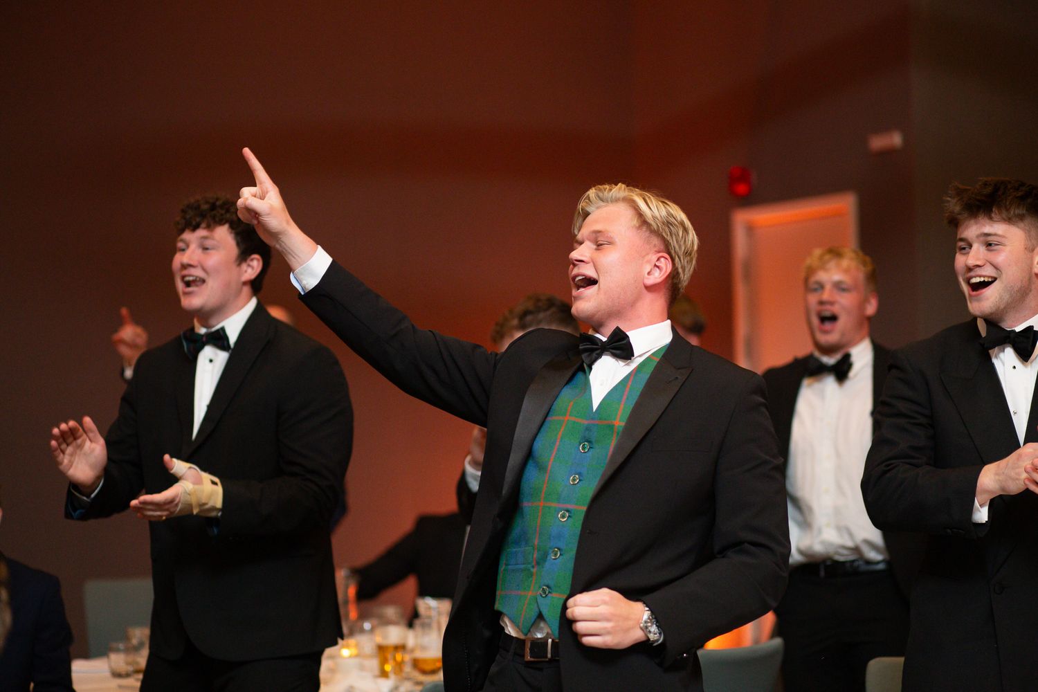 Animated guests in formal wear having enthusiastic discussions during evening banquet.
