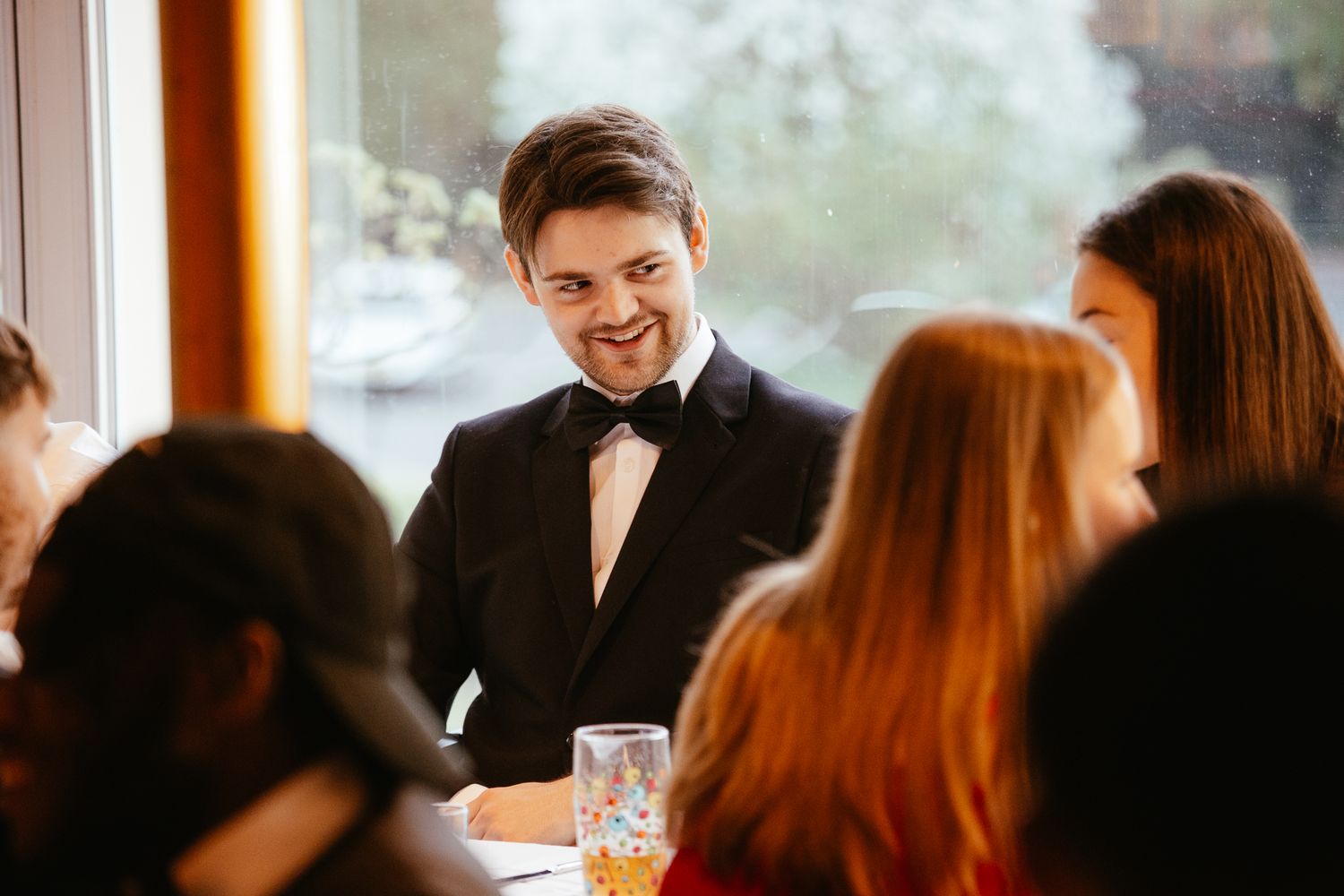 Guests in formal attire enjoying conversation during an elegant indoor reception.