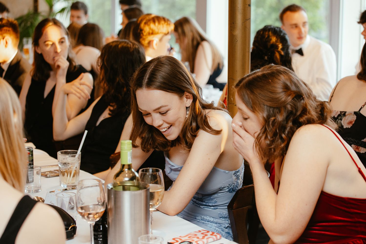 Friends sharing laughter and conversations during an elegant indoor social gathering.