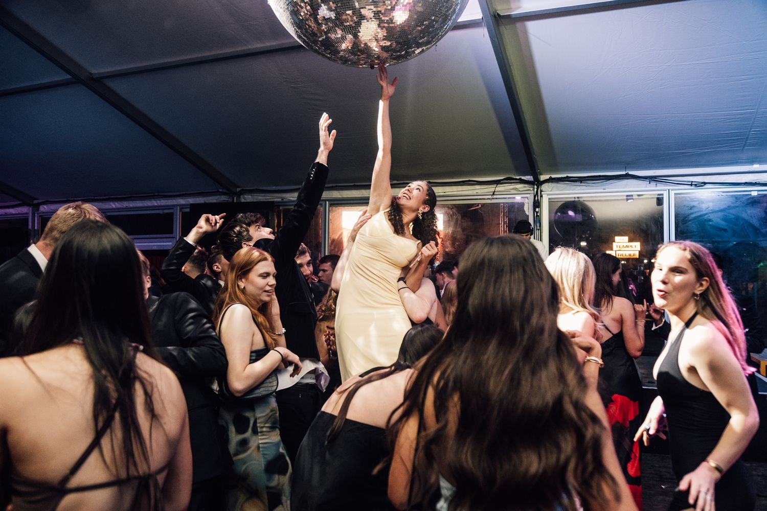 Nightclub dance floor with disco ball and party lighting.