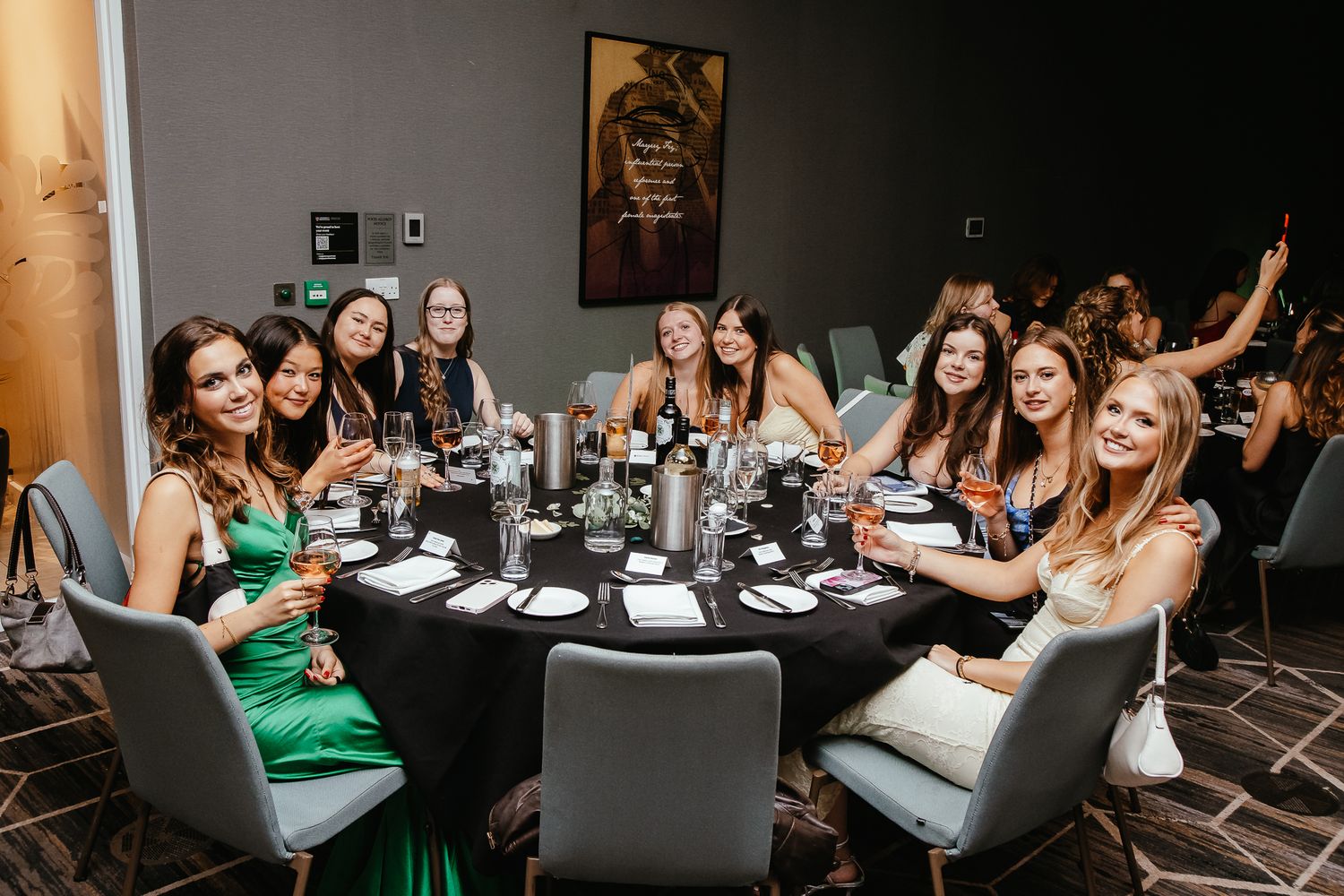 Wedding reception dinner party with guests seated at tables in dark room.