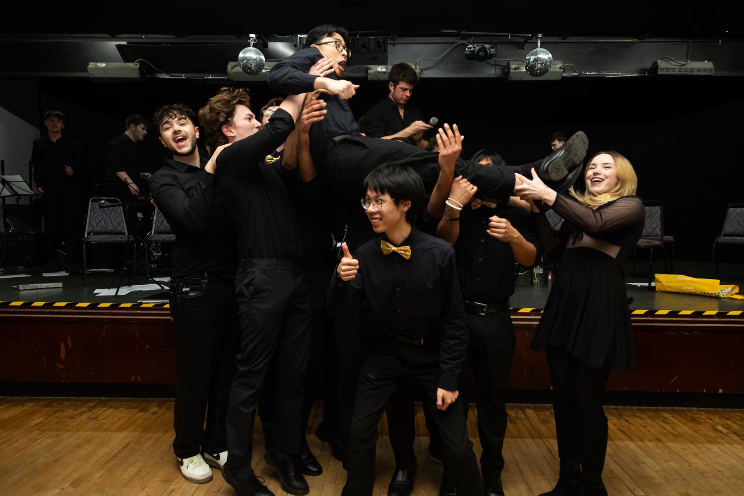 Group of formally dressed people celebrating and dancing at a social gathering.