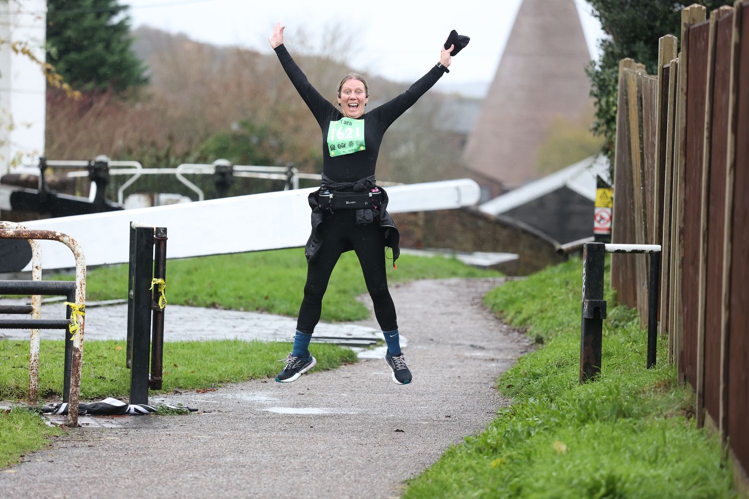 Person jumping over wooden barriers on an outdoor trail or obstacle course.