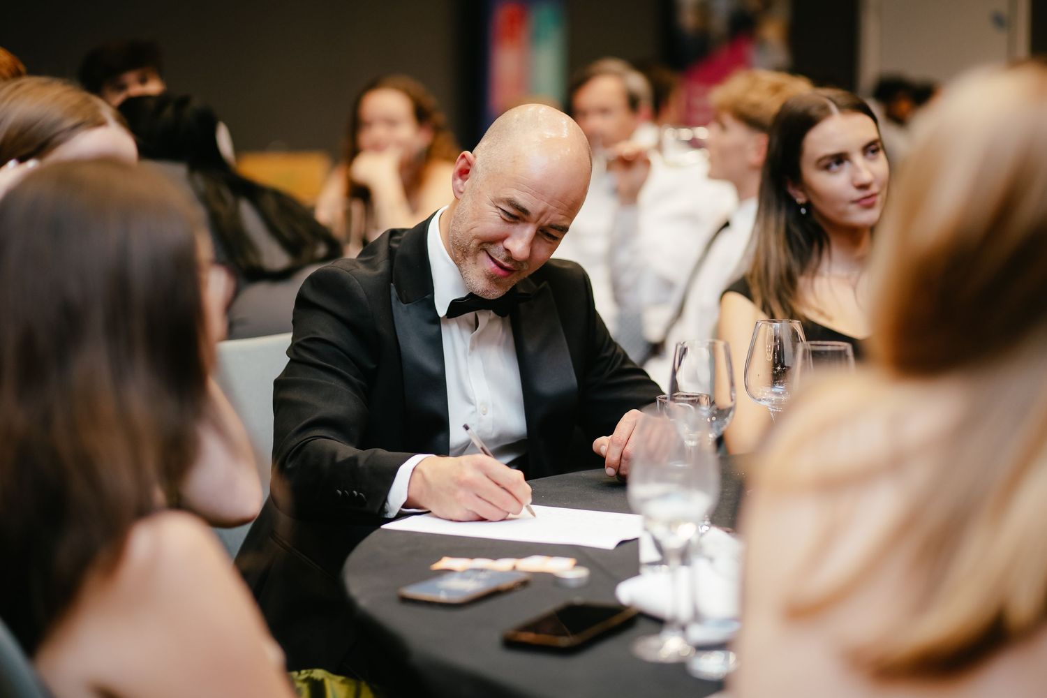 A series of candid moments captured at an elegant wedding reception showing guests signing a guestbook.