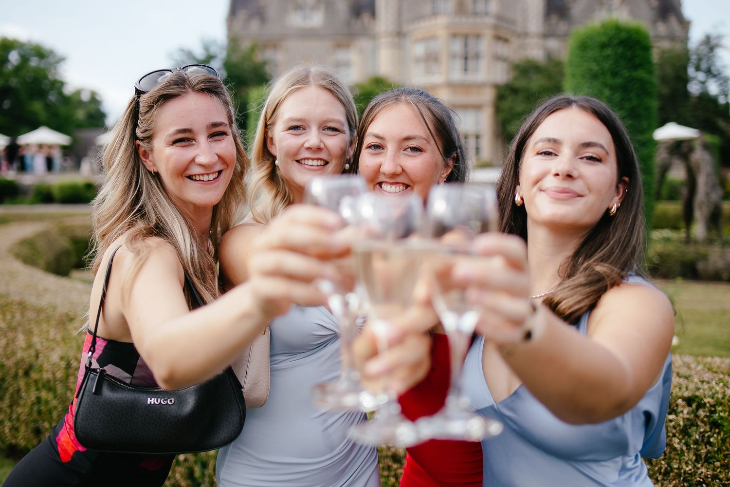 A group celebrates joyfully during an outdoor event with champagne toasts and laughter.