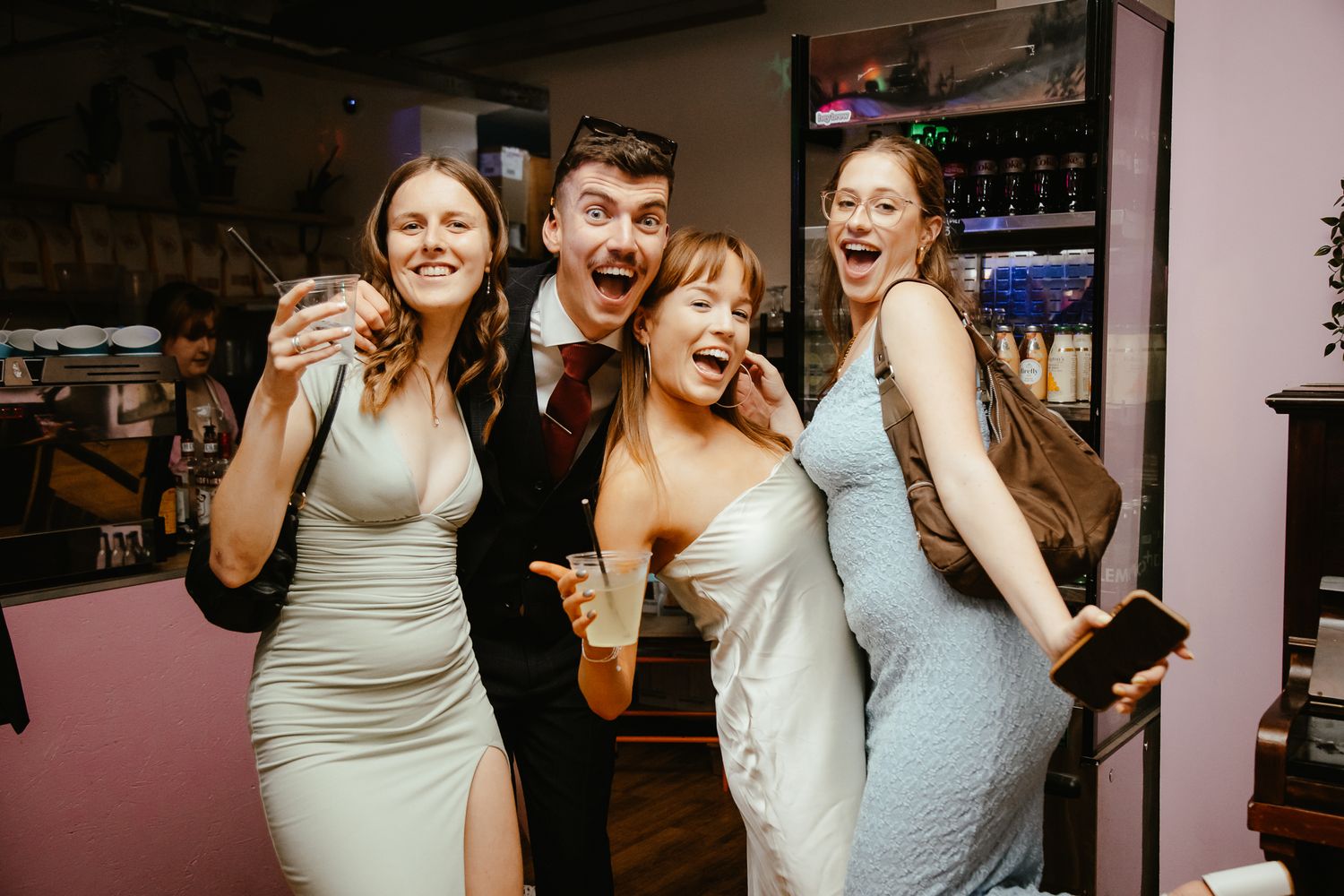 Party guests dancing and celebrating in a dimly lit dance floor.