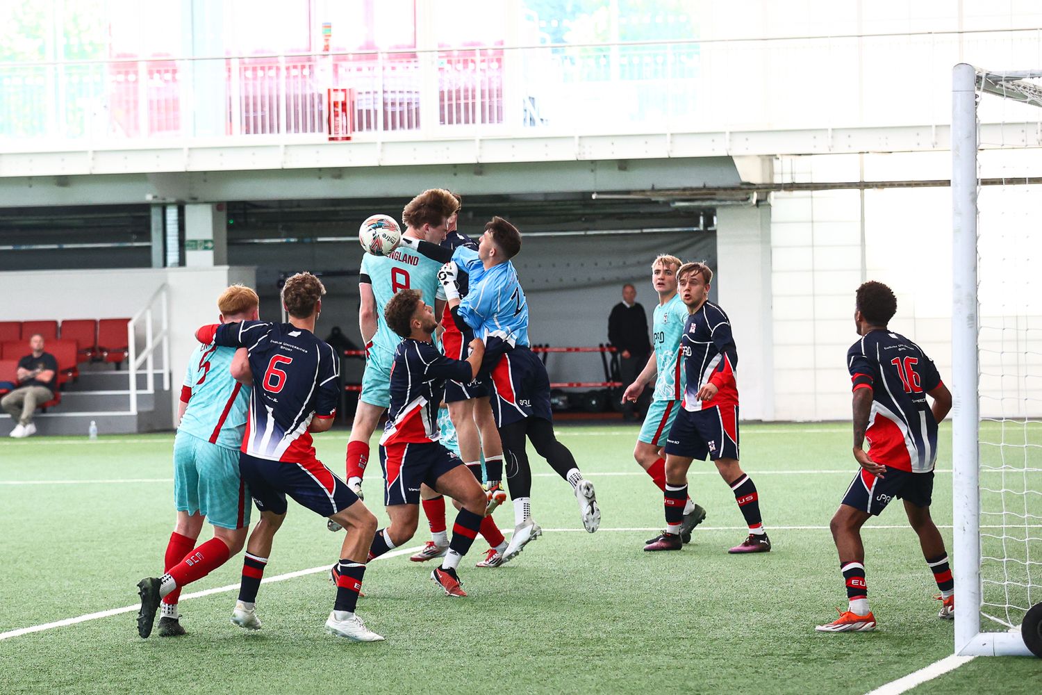 Soccer training session showing players in coordinated defensive drills on an indoor field.