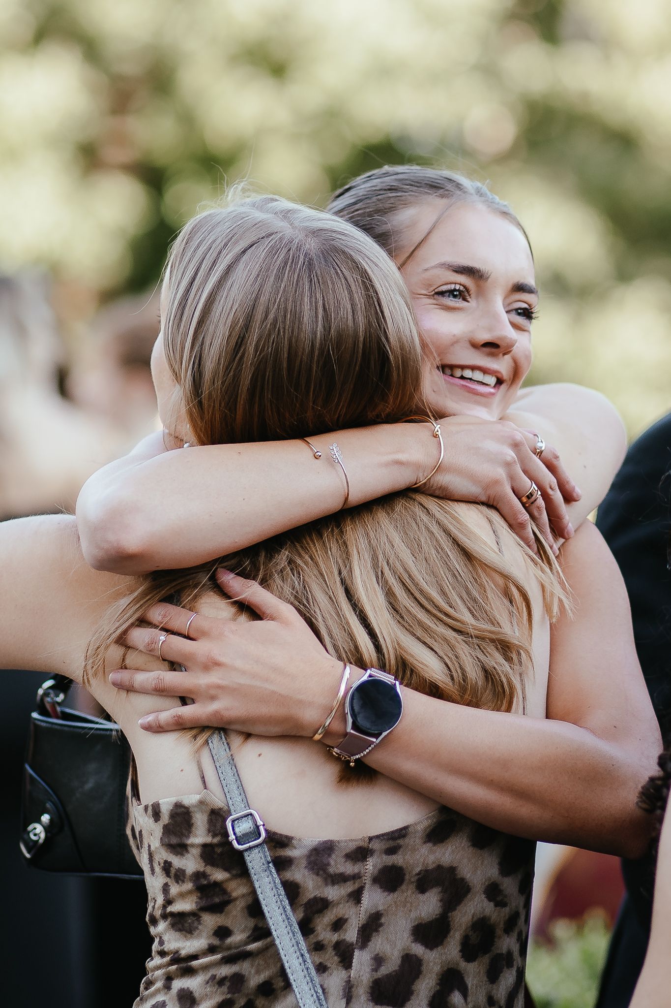 Two people sharing an emotional embrace while wearing dark clothing outdoors.
