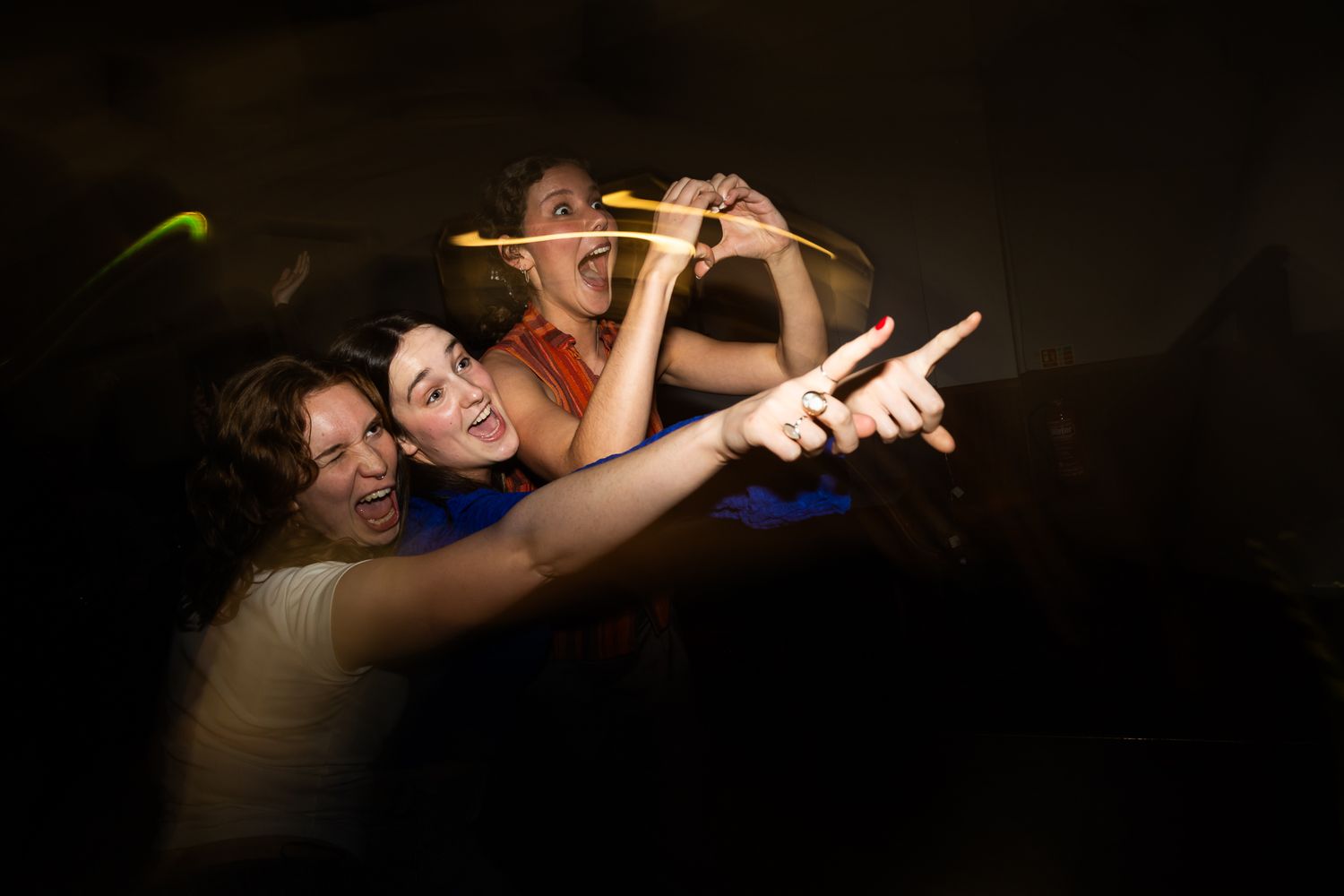 Silhouettes of people dancing and celebrating against a dark background.