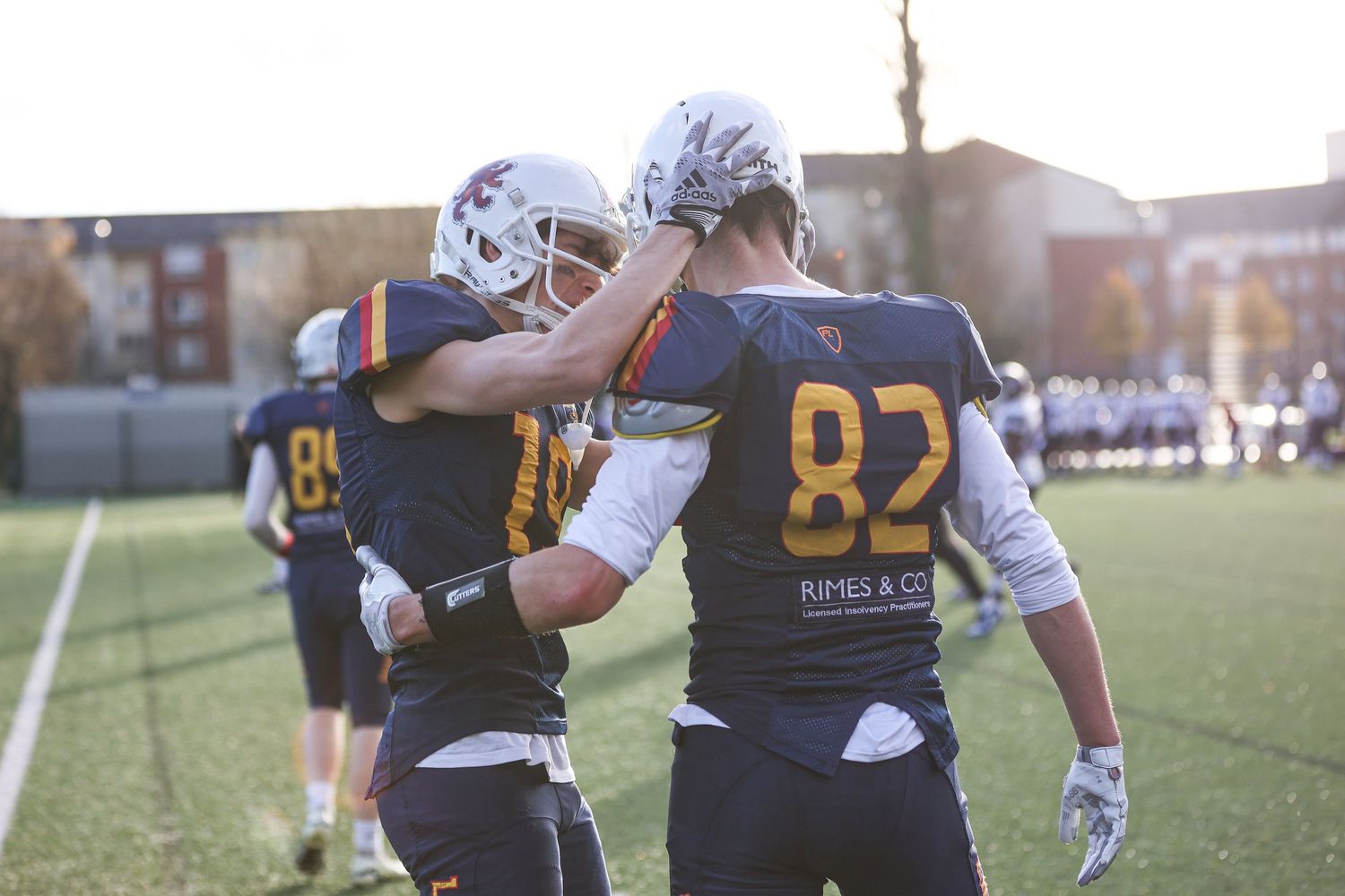 Football players in navy and gold uniforms practicing defensive formations.