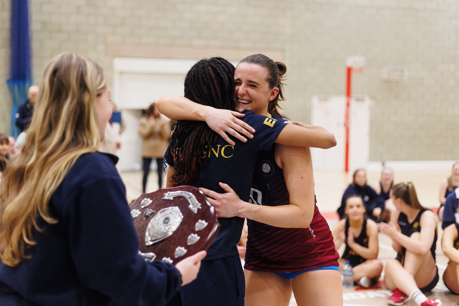 Athletes celebrate and embrace during an indoor sports match.