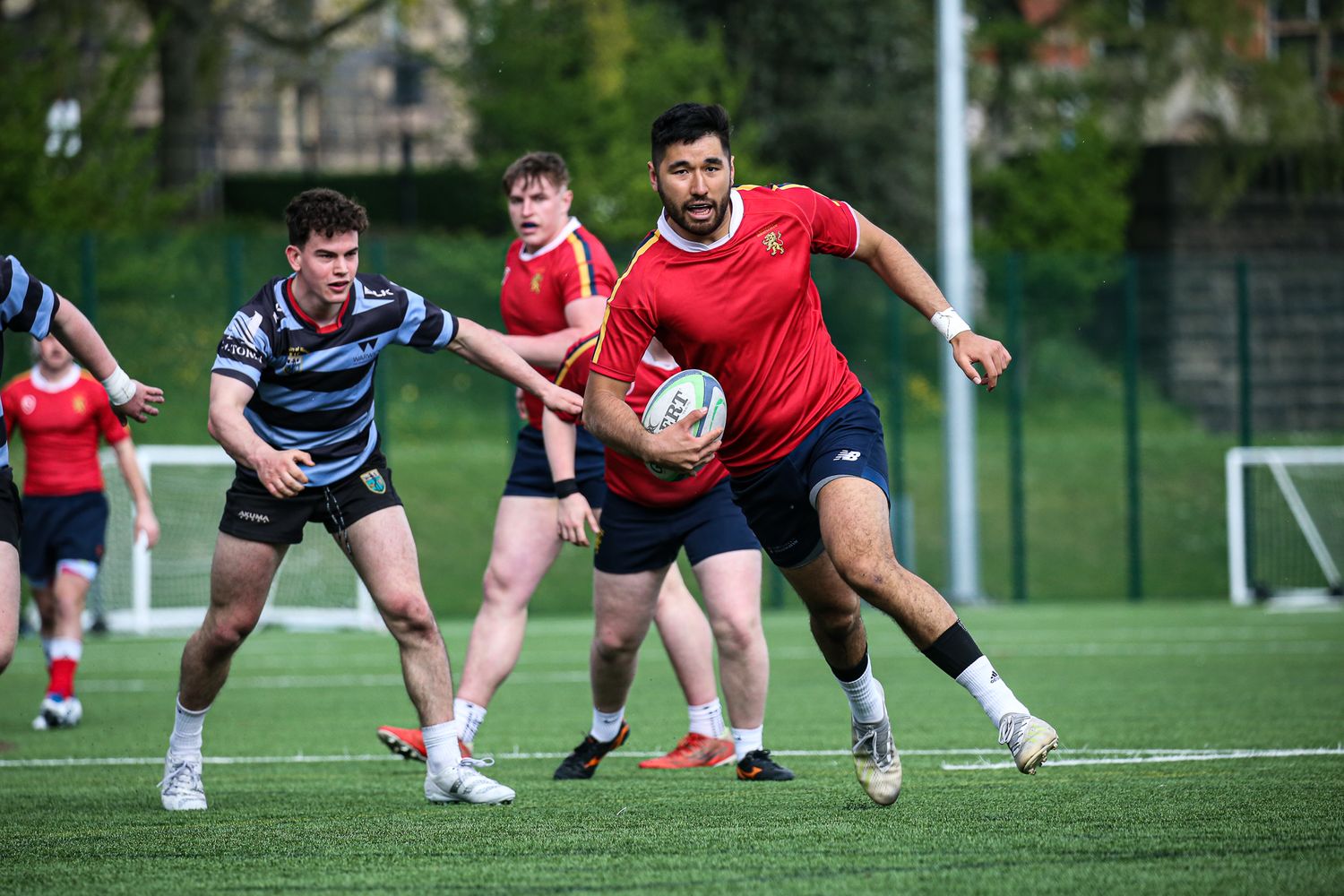 Rugby players engaged in a scrimmage during a match on a green field.