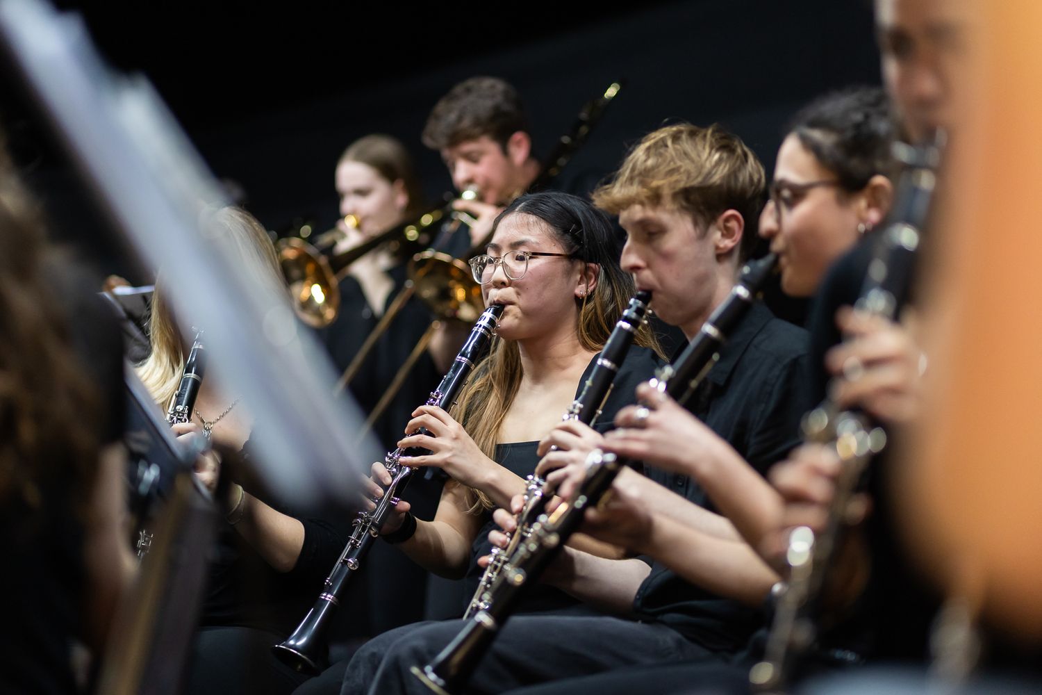 Orchestra musicians playing clarinets during a performance.