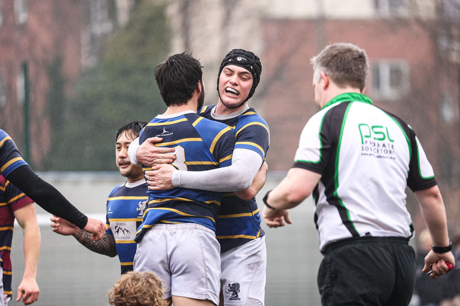 Players engage in a scrum formation during a competitive rugby match.