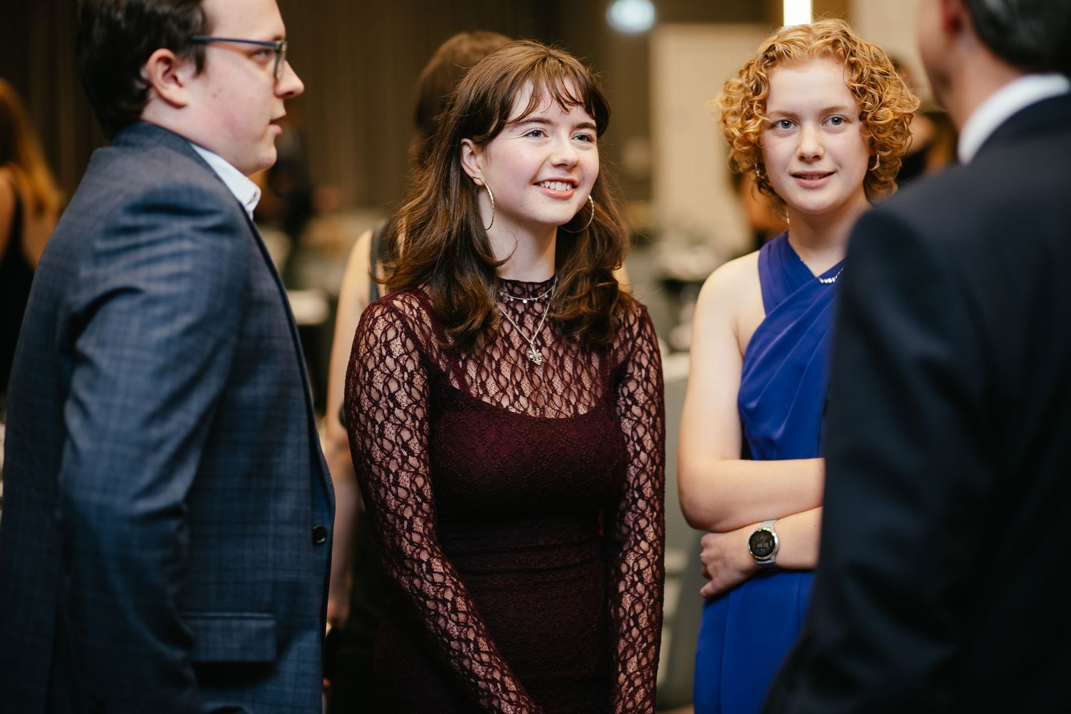 Professional networking event showing attendees engaged in conversation at an evening gathering.