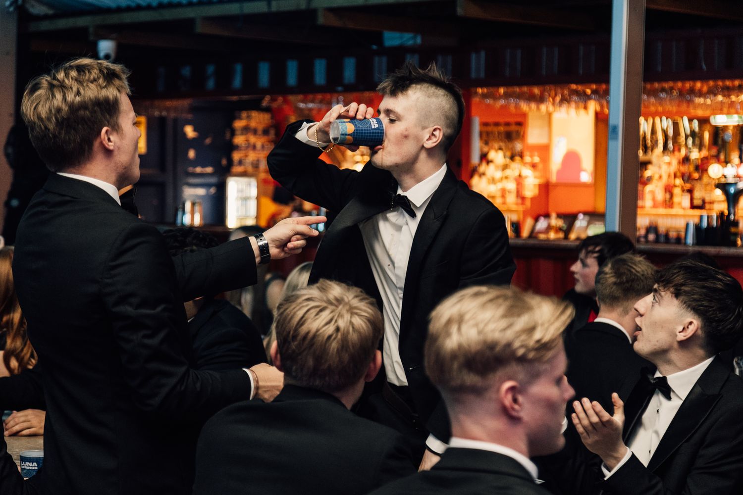 Formal event gathering with people in black tie attire.